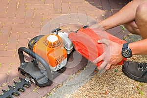 Man fills hedge trimmer with fuel