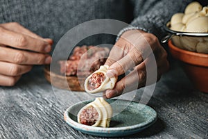 Man fills some Catalan galets with ground meat