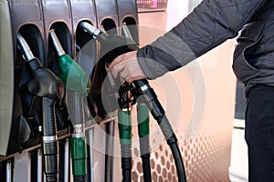 Man fills up his car with a gasoline at gas station. Petrol station pump. To fill car with fuel. Gasoline and oil products