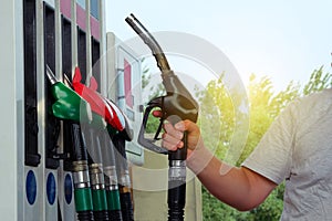 Man fills up his car with a gasoline at gas station. Petrol station pump. To fill car with fuel. Gasoline and oil products concept