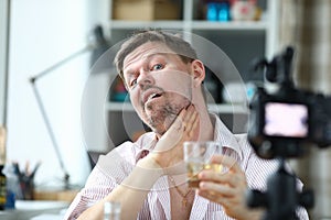Man filming a video blog about an alcoholic drink