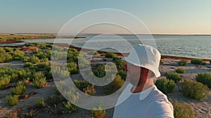 A man films himself against the backdrop of the Kinburn Spit landscape early in the morning