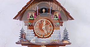 Man finger adjusts vintage house-shaped wall clock to signal