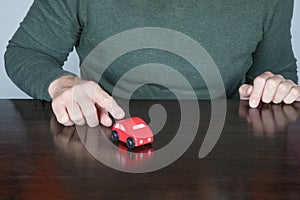 Man finger points a toy car