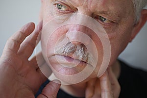 Man with fingers on painful jaw