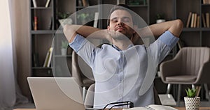 Man finished computer work takes off glasses lean on chair