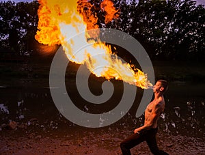 Man fire-eater blowing a large flame