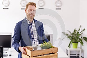 Man fired from work carrying things in box while leaving office photo