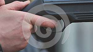 A man firing an air gun. Close-up of her hands.