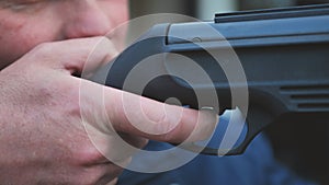 A man firing an air gun. Close-up of her hands.