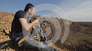 Man firing customised russian machine gun, wide