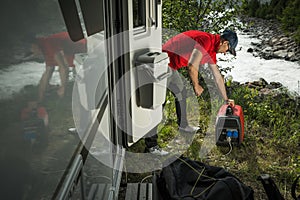 Man Firing Up Gas Powered Portable Inverter Generator To Hook Up His Camper Van