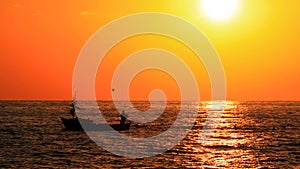 Man on fisher boat at sunset