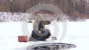 Man fishes with a fishing rod in winter fishing.