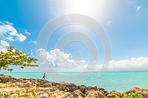 Man fishing in the beautiful Bas du Fort shore under a shining sun