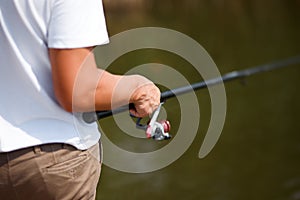 Man fishing and holds the angling rod. photo