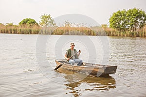 Man fishing on a lake- Fisherman in fishing boat