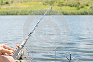 Man fishing on a lake with a spinning reel and rod