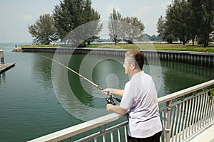 Man fishing by the lakeside. Conceptual image