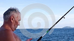 A man is fishing on the ocean.