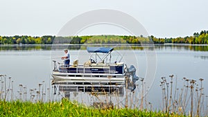 Man Fishing off a Pontoon Boat on Lake