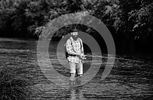 Man fishing and relaxing while enjoying hobby. A fisherman with fishing rod on the river. Fisherman and trout. Holding