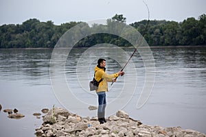Man fishing on river coast