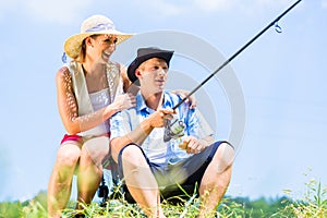 Man with fishing rod angling at lake enjoying hug