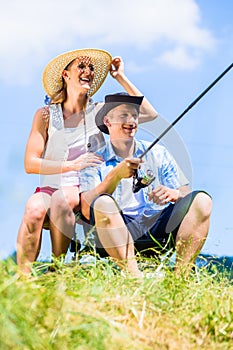 Man with fishing rod angling at lake enjoying hug