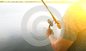 Man is fishing with rods near the lake. Hobby outdoors. Catching fish in the nature with poles