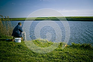 Man fishing on shore of lake photo