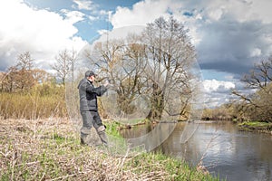 Man is fishing on a spinning rod from the shore