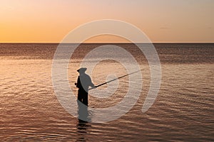 Man fishing at sunset, Tombeau Bay, Mauritius