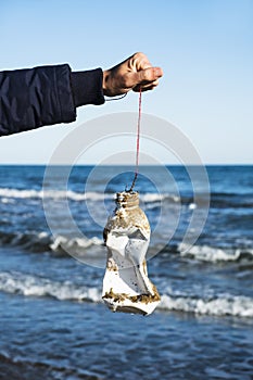 Man fishing a used plastic bottle in the sea