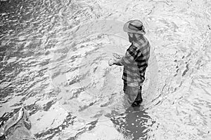 Man fishing in water. Bearded man catching fish. Young man fishing. Fisher fishing equipment. Fisherman with rod and