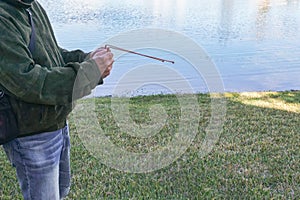 a man is standing by the water with a fishing pole