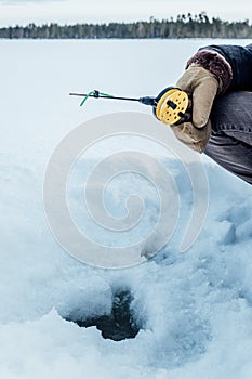 Man fishing in winter on lake