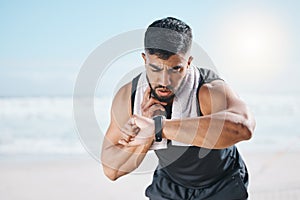Man, fitness and checking watch for pulse, heart rate or performance on break after workout on the beach. Fit, active