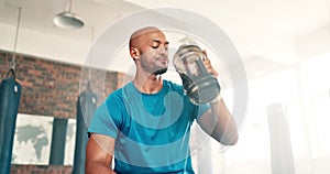 Man, fitness and drinking water on break at gym for hydration, recovery or natural sustainability in workout. Thirsty or