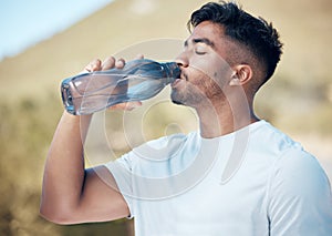 Man, fitness and drinking water in nature for sustainability, running exercise or cardio workout outdoors. Thirsty male