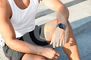 Man with fitness tracker after training outdoors, closeup