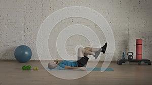 Man fitness trainer in sportswear doing legs cycle abs exercise for online class at the home studio. HDR BT2020 HLG