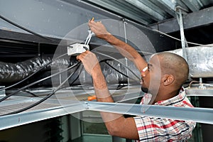 Man fitting cables into junction box