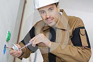 Man fitting electrical outlet in bathroom