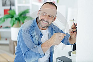 man fitting hook on wall