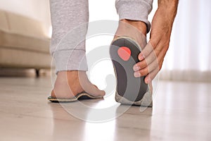 Man fitting orthopedic insole at home