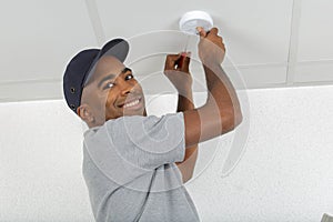 Man fitting smoke detector