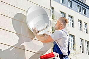 Man Fitting TV Satellite Dish photo