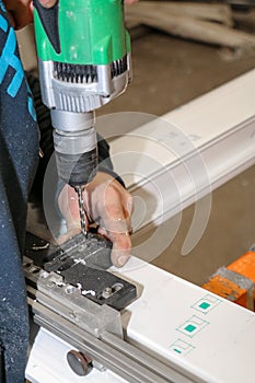 A man fixes an element for the realization of PVC window frames in a carpentry photo