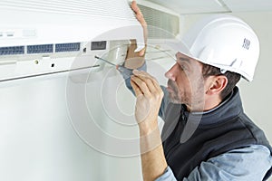 man fixing air conditioningsystem